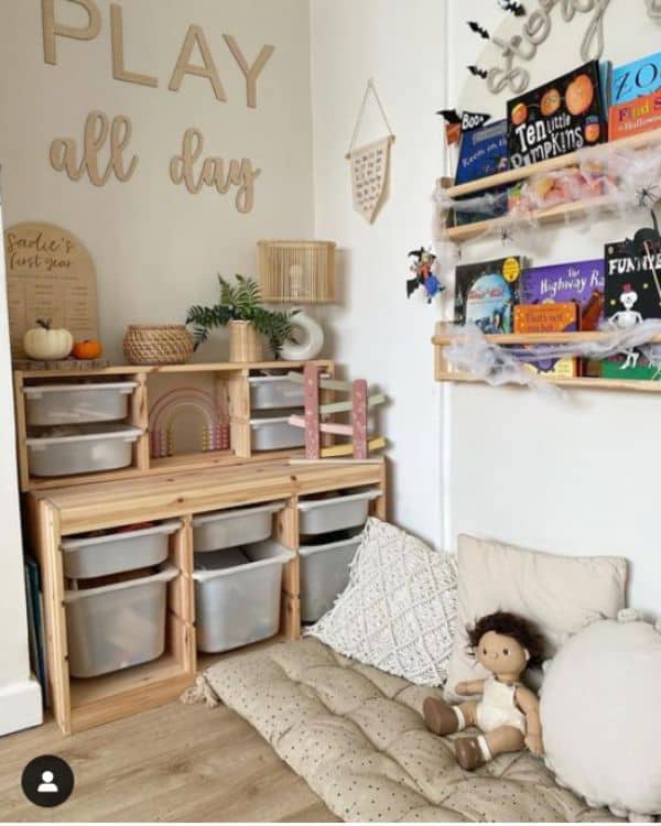 Kids Reading Corner Idea - A simple beige cushion on the ground with some floor pillows and some wooden floating shelves on the wall above to store books. 