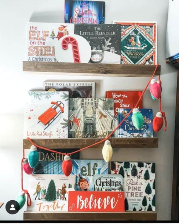 3 wooden floating shelves in  baby's nursery decorating with Christmas children's books and small Christmas decorations. 