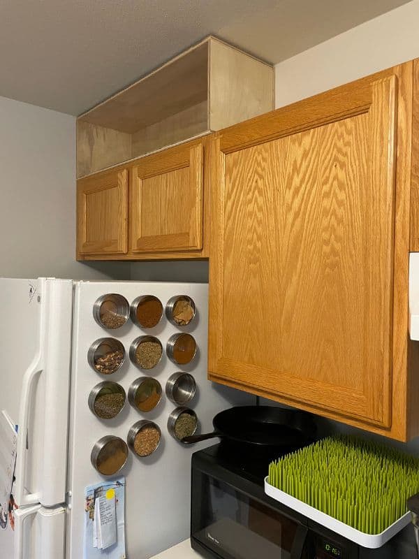 Image taken of the kitchen before extending the cabinets to the ceiling. One of the plywood boxes for above the cabinets is installed above the first cabinet. 