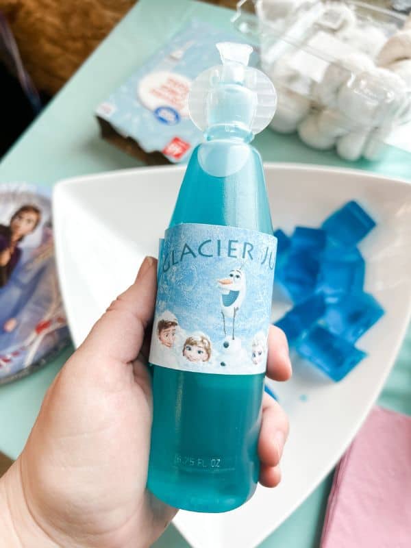 Frozen birthday party food ideas - blue Kool-Aid bottle with a label on it that says "glacier juice".