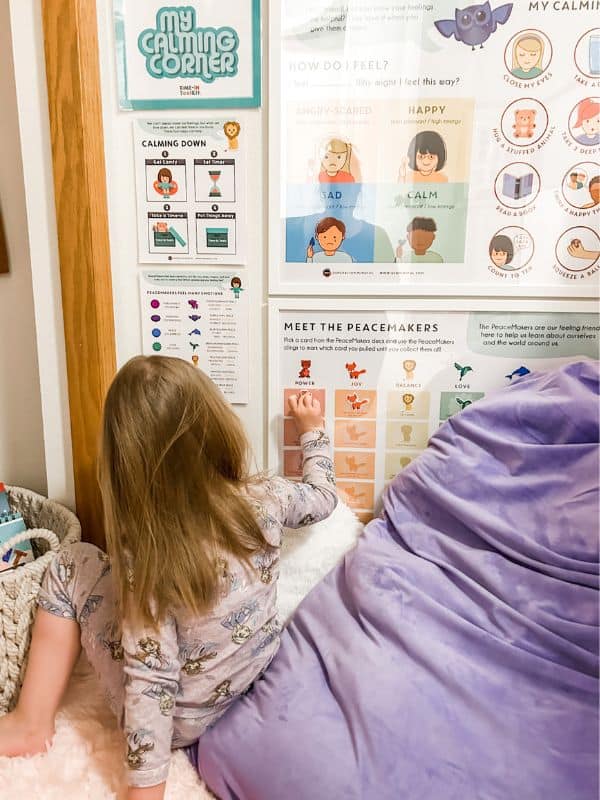 Young girl looking at the calming corner posters in her calm down area. 