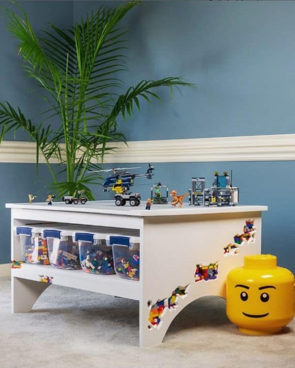 A Lego table with storage bins and Lego figures on top of the table. 