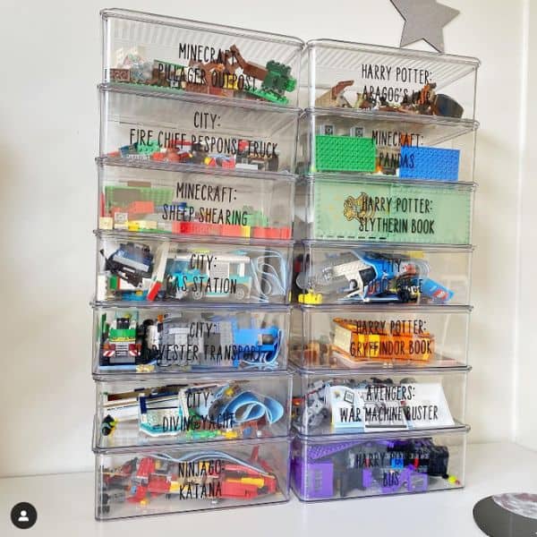 A clear plastic bin Lego storage system labeled with various Lego sets and pieces, organized by color and type.